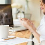 42842943 - coffee cup and businesswoman working with documents and laptop